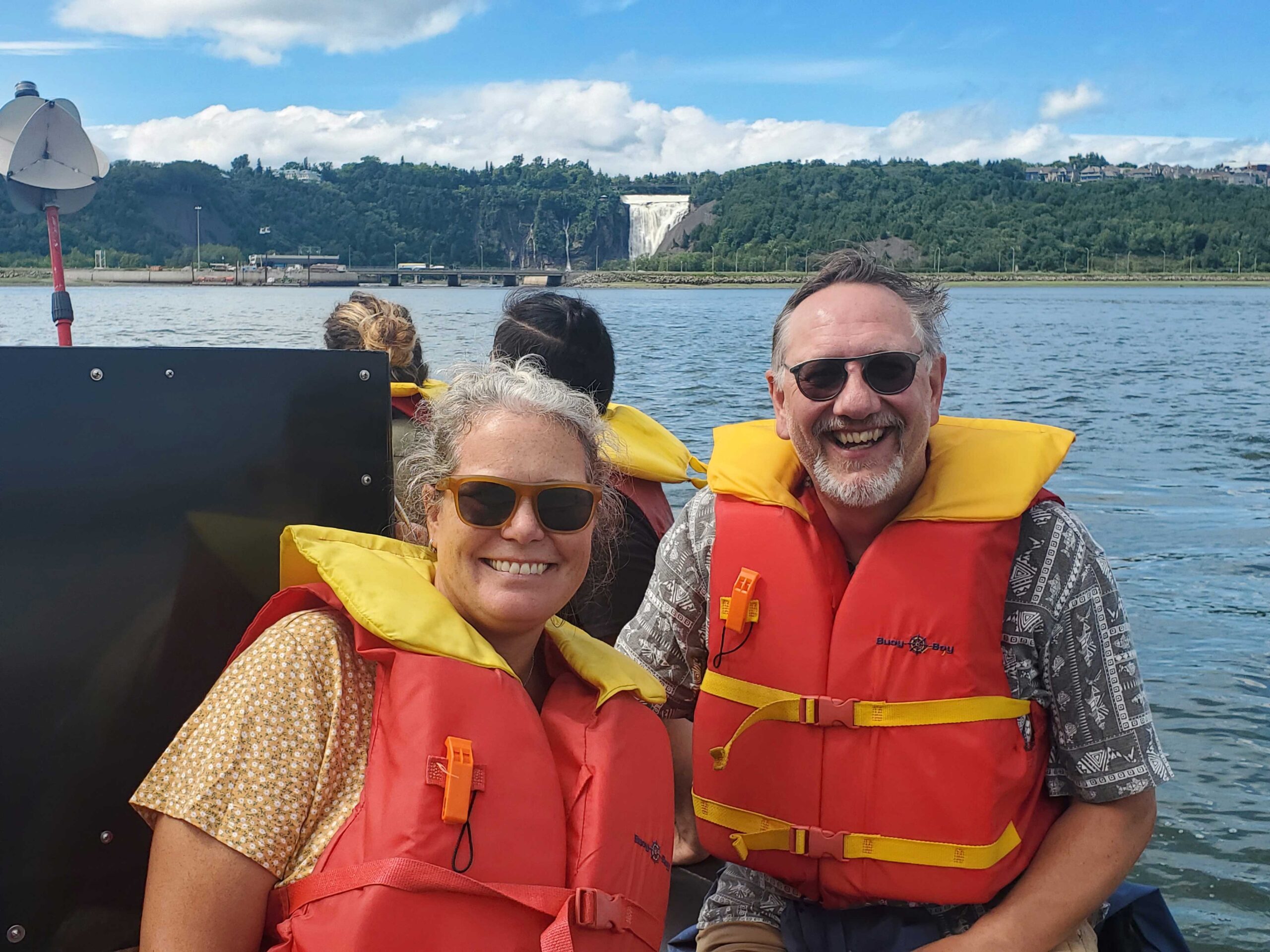 Ande and Jake on a boat tour of the St. Lawrence River with the Montmorency Waterfall in the background.