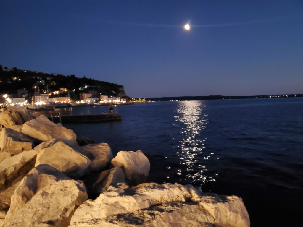 View of the moon over the waterfront in Piran, Slovenia