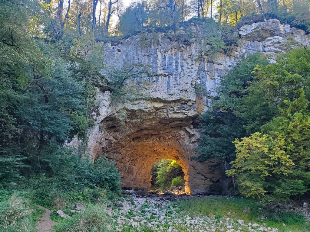 Rakov Škocjan arch that was once the wall of a cave with the afternoon sun illuminating the arch